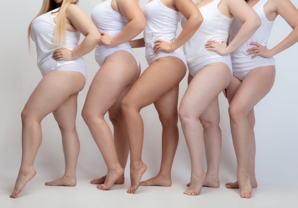 In love and harmony with myself. Close up of plus size young women posing on white background. Female models in white swimsuit. Concept of body positive, beauty, fashion, style, feminism.